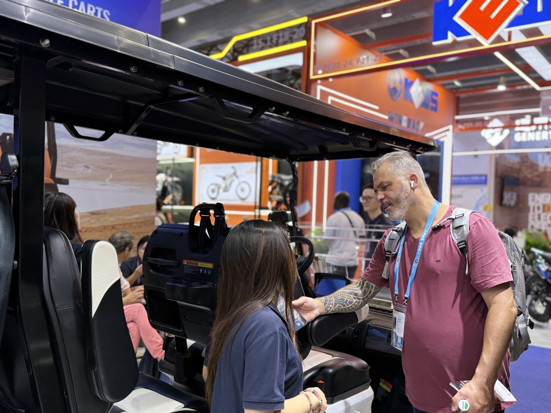 International buyer testing the seating and controls of an HDK electric golf cart at the Canton Fair